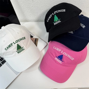 Classic embroidered baseball caps in white, black, navy, and pink on a white desktop