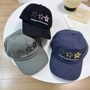 Three canvas baseball caps with star patterns and Romanticism embroidery on a white table