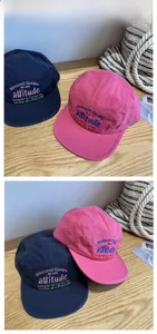 Detail of colorful 3D embroidery on five-panel cotton baseball caps with brand lettering
