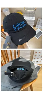 Detail view of adjustable metal buckle and blue 3D embroidery on black distressed cap