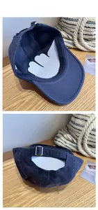 Detail view of navy blue cotton baseball cap with adjustable silver metal buckle