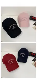 Close-up of vintage distressed baseball caps with flower and letter embroidery