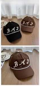 Detail view of cotton baseball caps featuring vintage BAD letter embroidery and white rope