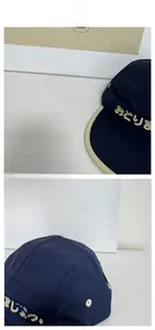 Macro view of navy five-panel camp cap with yellow embroidery and contrast piping