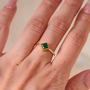Luxurious geometric square emerald zircon ring in gold finish on a model's hand