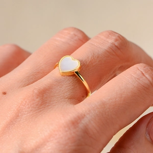 Gros plan détaillé d'une bague en argent 925 doré avec incrustation de nacre en cœur