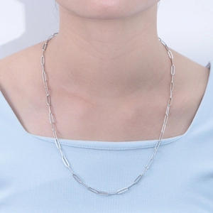 Detail of silver paperclip chain necklace showing long oval links on a model