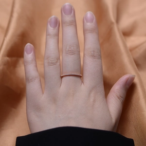 Close-up of minimalist rose gold ring with row of micro-set cubic zirconia on finger