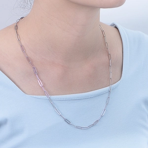 Minimalist silver paperclip link necklace for women shown on neck over light blue top