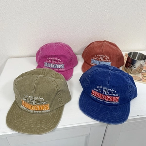 Group display of washed cotton baseball caps with vintage embroidery in four colors