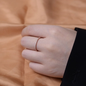Minimalist rose gold eternity ring with micro-paved cubic zirconia worn on a finger