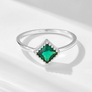 Macro shot of silver ring featuring square emerald-cut zircon with bezel setting