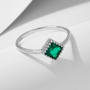 Detail of square emerald zircon on silver band with vintage beaded setting texture