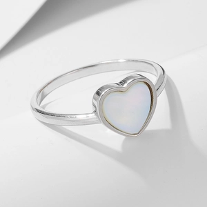 Vue macro d'une bague en argent 925 avec incrustation de nacre irisee en forme de coeur