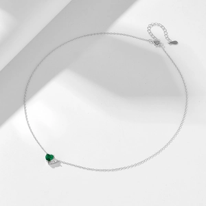 Dettaglio del ciondolo a cuore smeraldo e catena d'argento con chiusura a moschettone