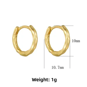 Detail view of 10mm golden wave textured hoop earrings with a lava style finish