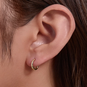 Minimalist hammered gold huggie hoop earrings featuring a unique textured finish