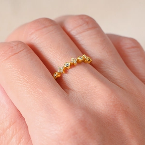 Macro detail of gold sterling silver ring with alternating round and star zircon settings