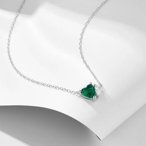 Collana in argento 925 con cuore verde smeraldo e zircone bianco su sfondo bianco