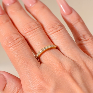Macro shot of gold eternity band ring featuring channel-set square-cut cubic zirconia
