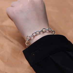 Detail of silver S925 sterling silver chain bracelet worn on wrist with black sleeve