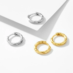 Minimalist sterling silver hoop earrings with irregular lava texture in gold and silver finish