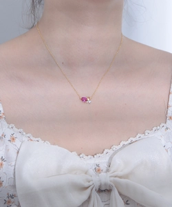 Detail view of a pear-shaped pink ruby pendant and zircon on a gold s925 silver chain