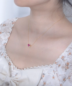 Detail of s925 silver heart necklace with pink gemstone and zircon on a model