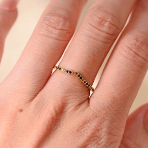 Macro detail of V-shaped gold ring with multi-colored rainbow stones for women
