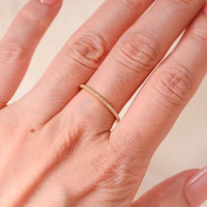 Macro shot of minimalist gold band with micro-pave crystals on the ring surface