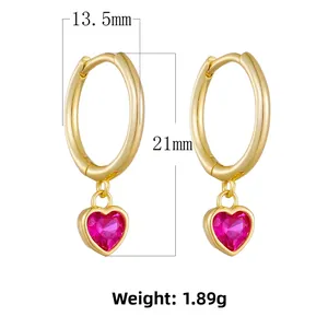 Detailed view of 18K gold hoop earrings with magenta heart-shaped zircon pendants