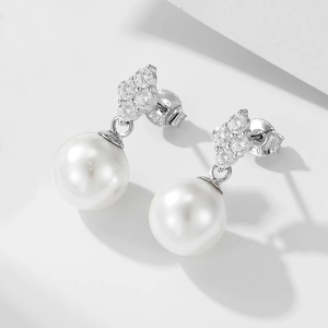 Close-up of S925 silver clover earrings with sparkling zircon and glossy white pearls