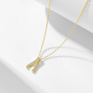 Detail of gold wishbone pendant with pavé set white zircons on fine chain
