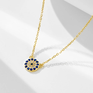 Macro detail of gold S925 silver necklace with blue crystal Evil Eye round pendant
