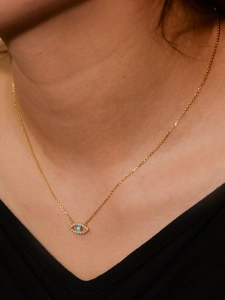 Close-up of S925 sterling silver evil eye necklace with blue zircons on model neck