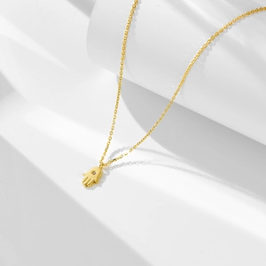 Detailed view of S925 silver golden Hamsa hand necklace with zircon stone on geometric base