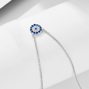 Macro shot of S925 sterling silver evil eye pendant with blue and white crystals