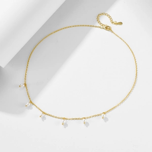 Detail of elegant gold chain necklace featuring six lustrous white pearls and adjustable clasp