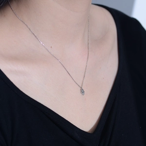Gros plan du collier avec pendentif main de Hamsa en argent 925 et zircon sur un mannequin