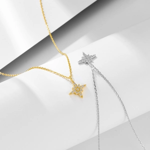 Sparkling silver and gold eight-pointed star necklaces with crystals on white background