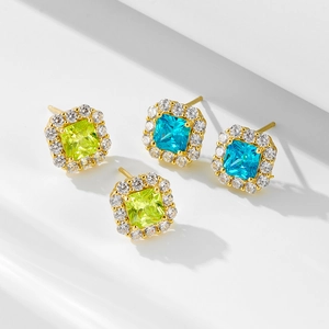 Close-up of halo-set princess cut yellow and blue zircon earrings in gold-plated silver