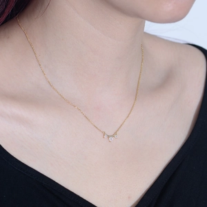 Gros plan d'un collier en argent 925 doré avec trois pendentifs en zircone sur le cou