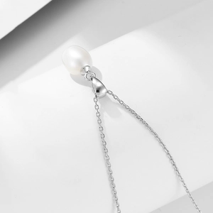 Vue macro d'un pendentif perle naturelle en goutte avec une fine chaîne en argent