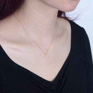 Close-up of a gold Hamsa hand pendant necklace with sparkling white cubic zirconia