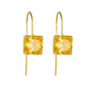 Détail macro de boucles d'oreilles zircon jaune avec crochets dorés et serti à 4 griffes