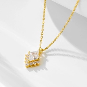 Detail shot of a geometric rhombus zircon pendant on a delicate gold sterling silver chain