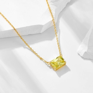 Elegant gold necklace with a rectangular yellow zircon pendant set on a textured white stone