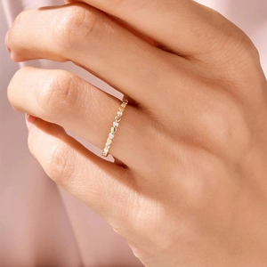 Minimalist gold sterling silver ring with small zircons worn on a finger in close-up shot