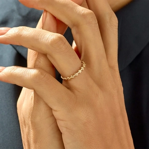 Close-up of a gold olive leaf ring on hand showcasing delicate texture and metal finish