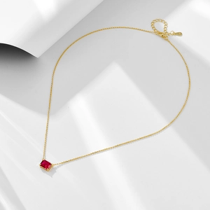 Macro shot of S925 hallmark on a gold-plated necklace with a red zircon pendant